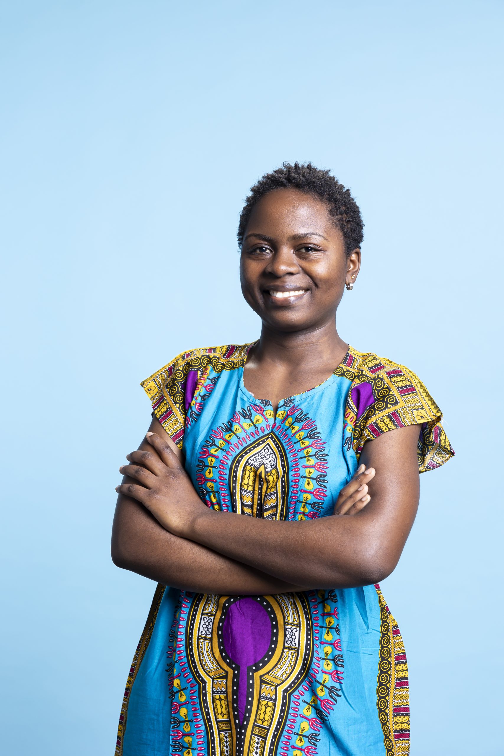 Portrait of cheerful woman standing with arms crossed on camera, feeling proud and confident wearing a traditional ethnic costume. African american gorgeous feminine model posing in studio.